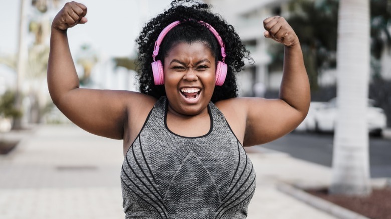 Happy woman flexing her muscles