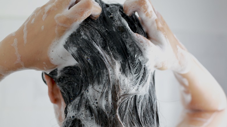 woman shampooing hair in shower