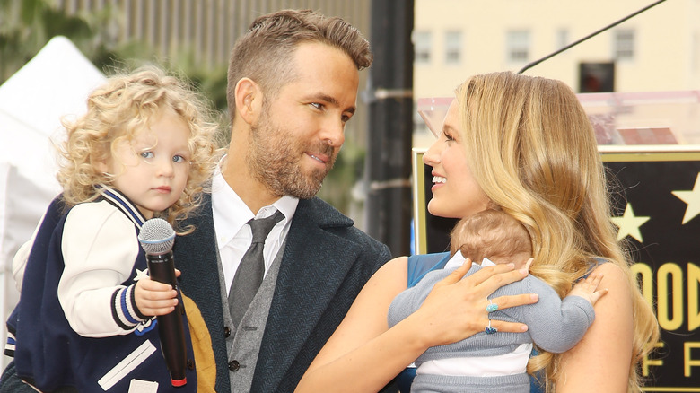 Ryan Reynolds and Blake Lively holding their children