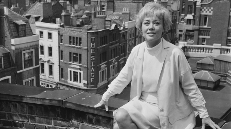 Glynis Johns sitting on a rooftop