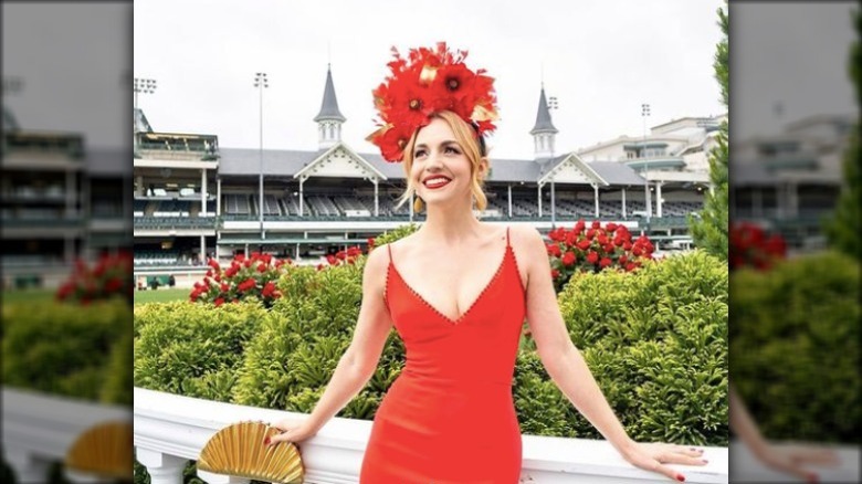 woman posing at derby in red outfit