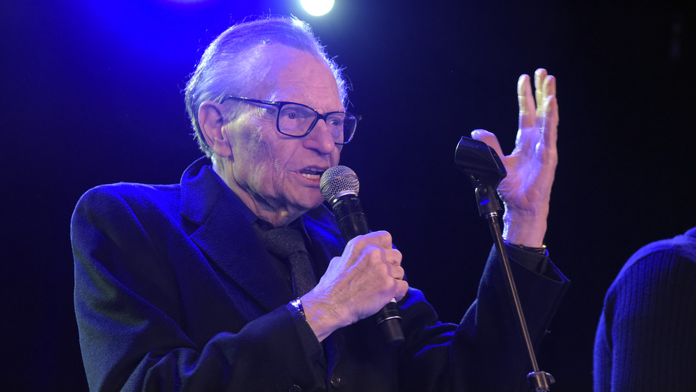 Larry King onstage with a microphone