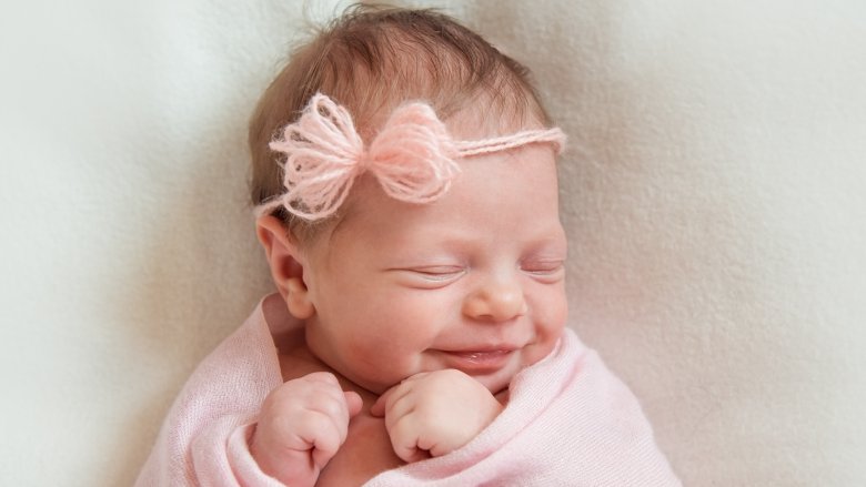 smiling baby with pink bow