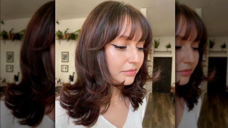 Person with wispy bangs and layered hair