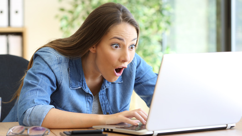 shocked woman looking at laptop