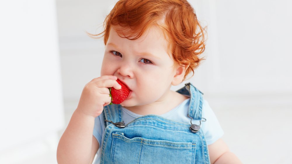 toddler eating a strawberry