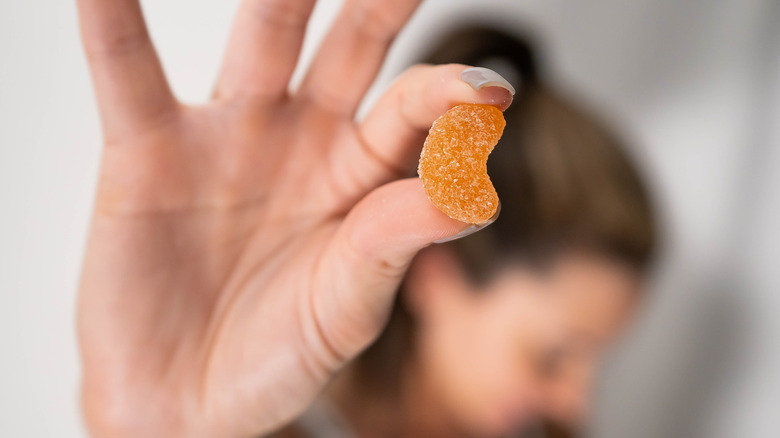 woman holding CBD gummie