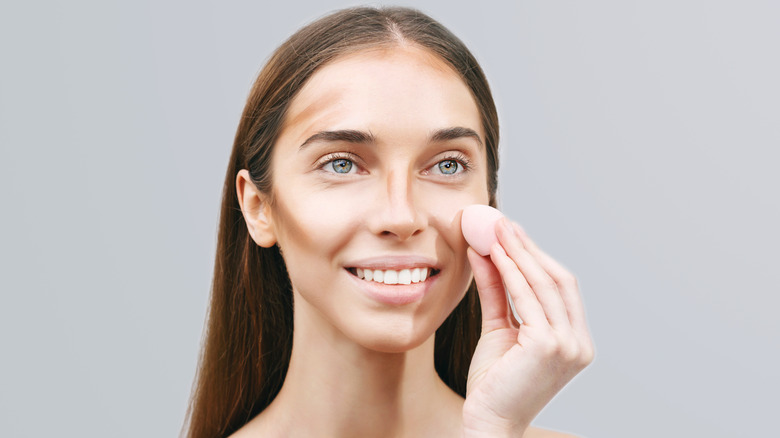 Woman contouring with sponge