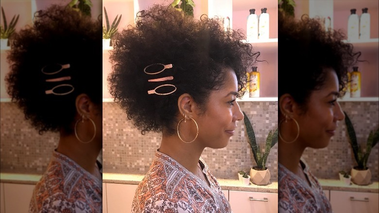 Woman with curly Afro wearing three barrettes