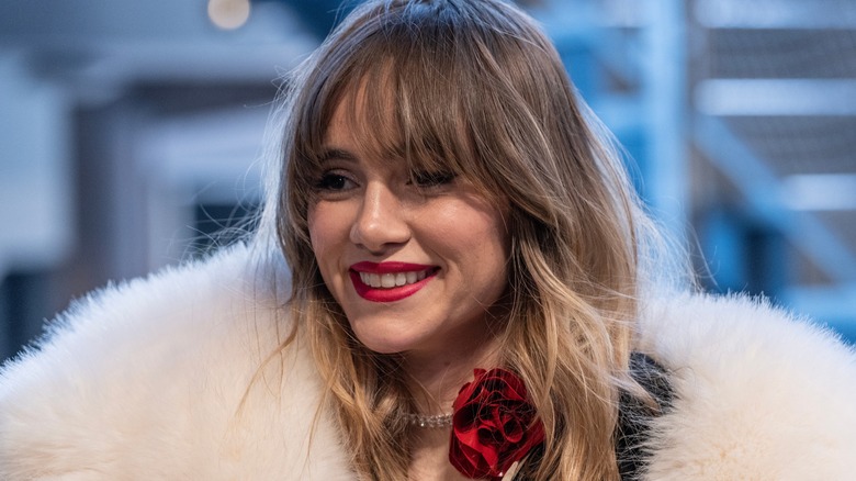 Suki Waterhouse smiling in fur coat