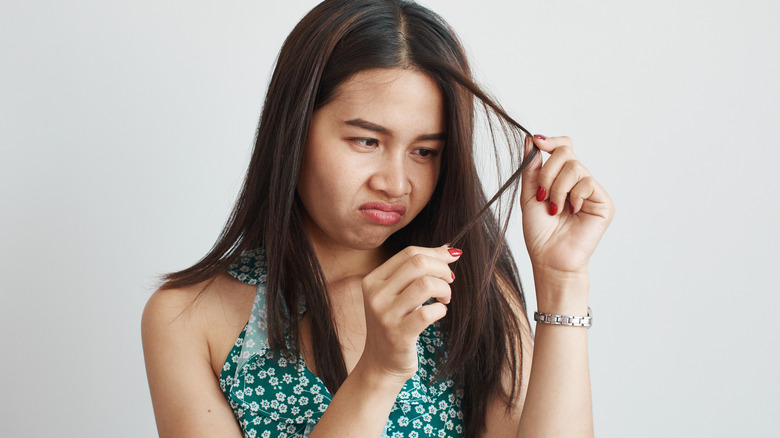 Woman looking at her hair ends