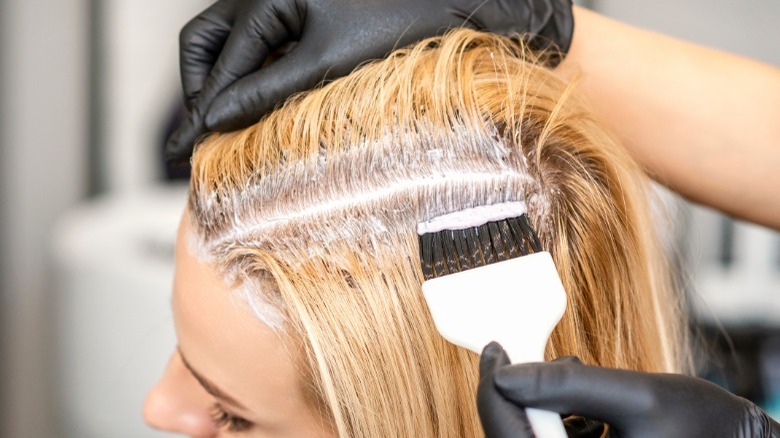 Woman getting hair roots dyed