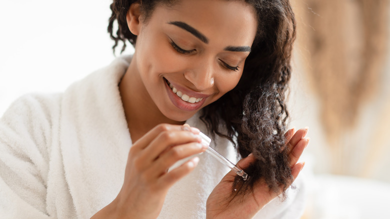 Woman applying product to hair ends