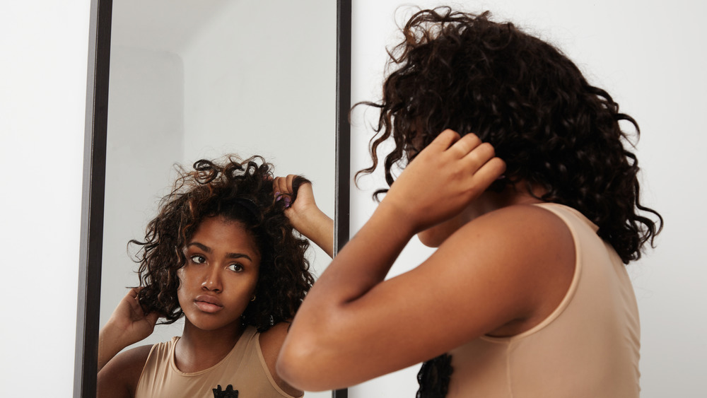 Woman putting on a wig