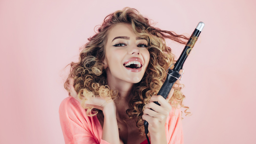 Woman with curling iron 