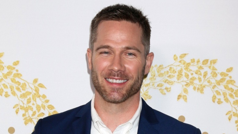 Luke Macfarlane smiling on the red carpet