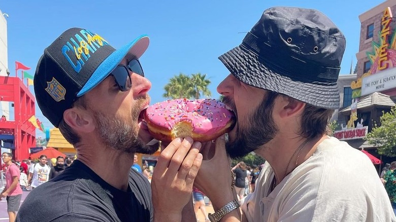 Andrew Walker and Tyler Hynes sharing a donut