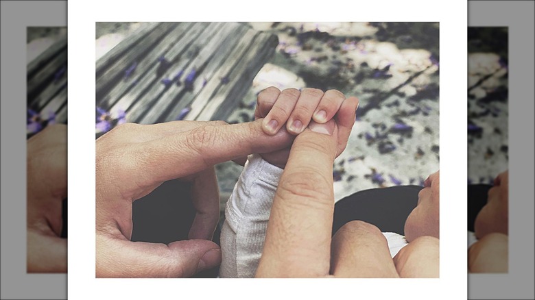 Chris McNally and Julie Gonzalo touching their daughter's hand