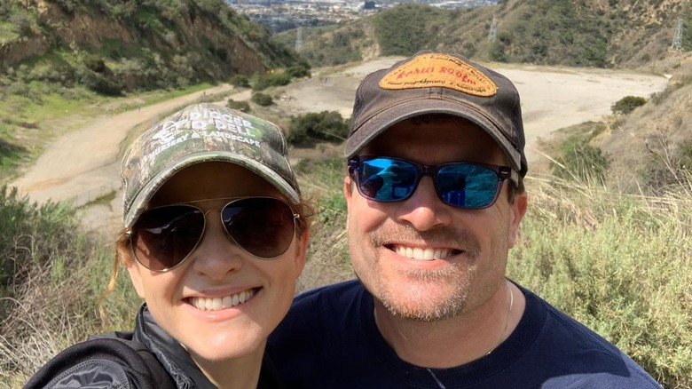 Sarah Drew and Peter Lanfer smiling and wearing sunglasses