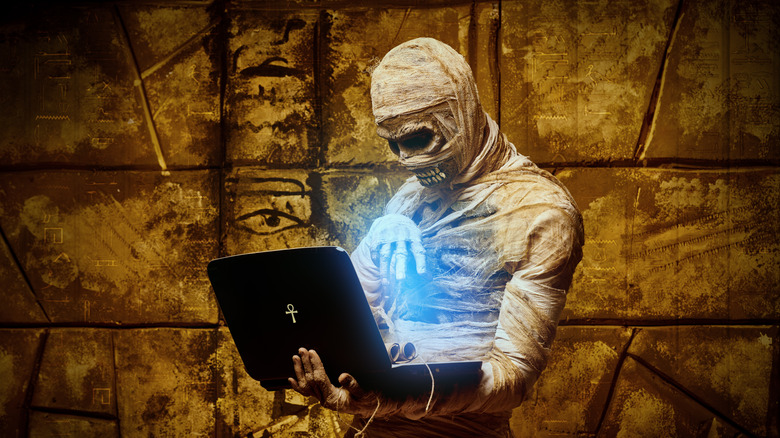 Halloween mummy holds a laptop