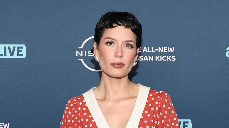 Halsey posing in a polka dot dress with close-cropped black hair