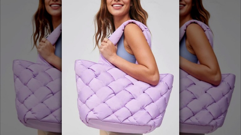 Model holding a large purple tote bag