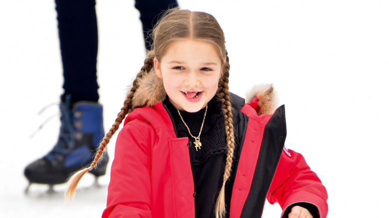 Harper Beckham ice skating at Wollman Rink in a red parka