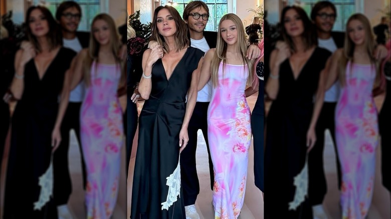 Victoria Beckham wearing black dress and Harper Beckham wearing pink dress