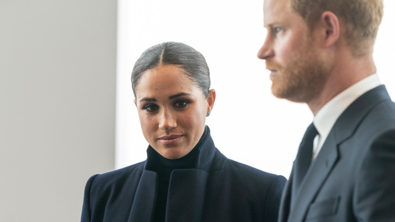 Megan and Harry at an event looking sullen