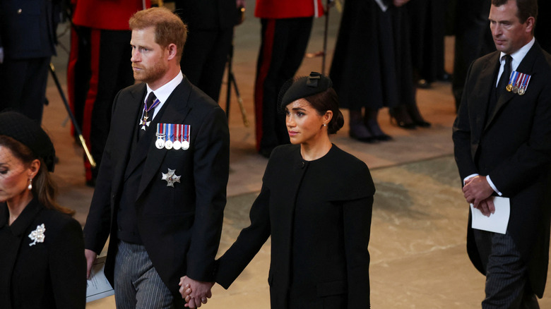 Meghan Markle and Prince Harry hold hands at Queen Elizabeth's funeral