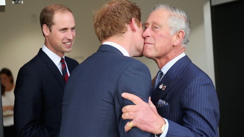 King Charles kisses Prince Harry on the cheek, Prince William watches