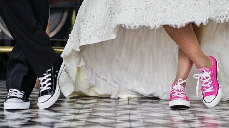 Bride and groom wear black and pink converse shoes