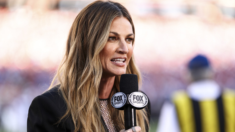 Erin Andrews on a football field, holding a Fox Sport microphone