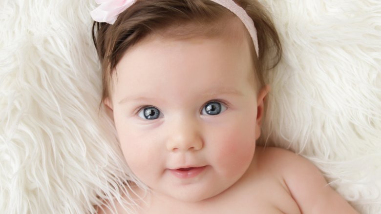 baby girl on white fur blanket