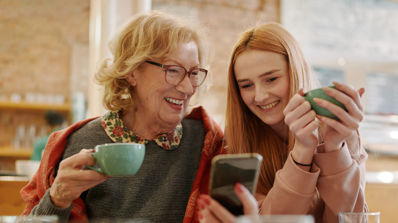 women smiling looking at phone