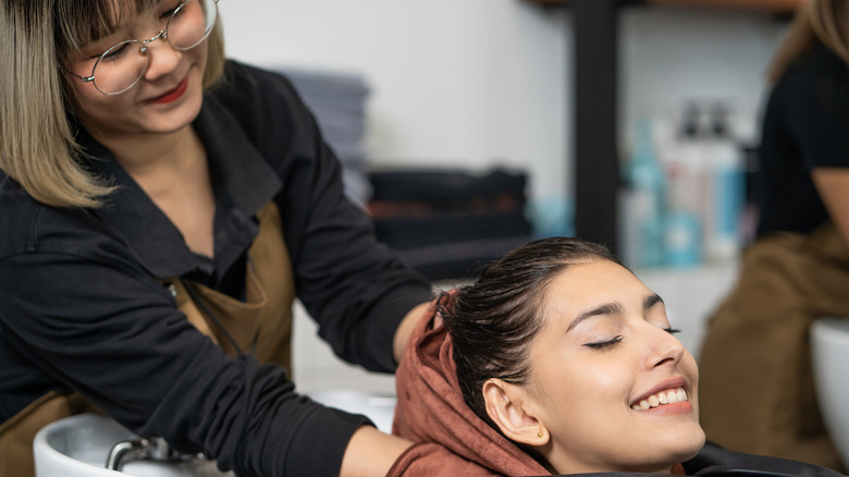 woman getting her hair washed by a hairdresser