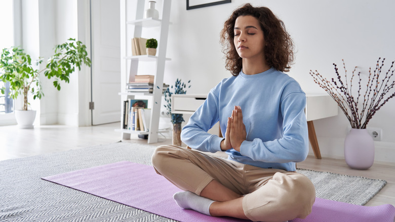 woman meditating on yoga mat