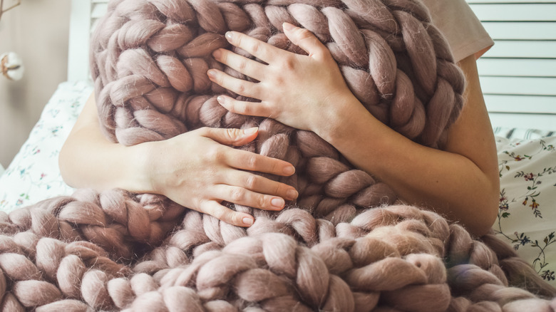 woman holding thick woven blanket