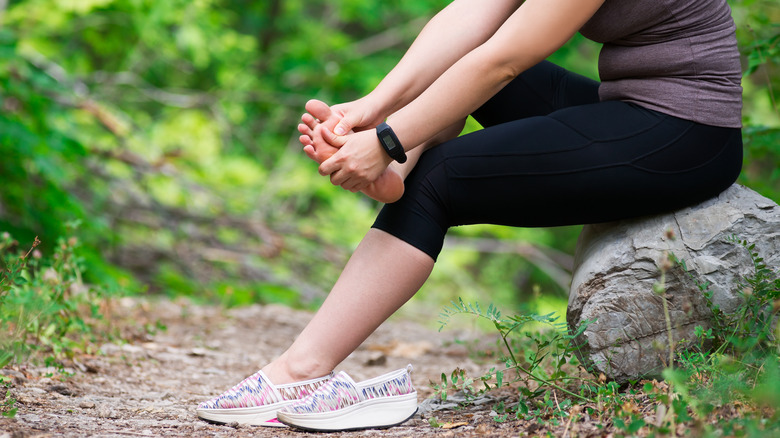 woman rubbing foot after running