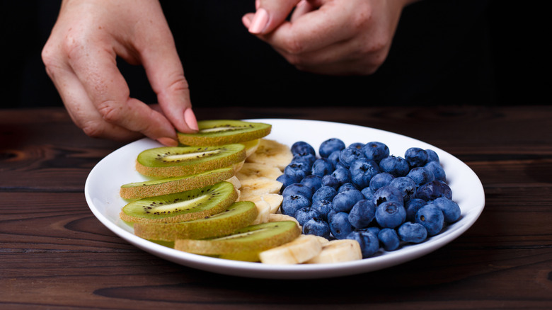 woman with a plate of only fruit