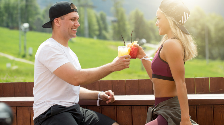 two people having drinks in workout clothes