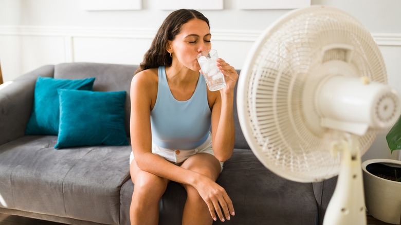 Woman cooling down with fan and water