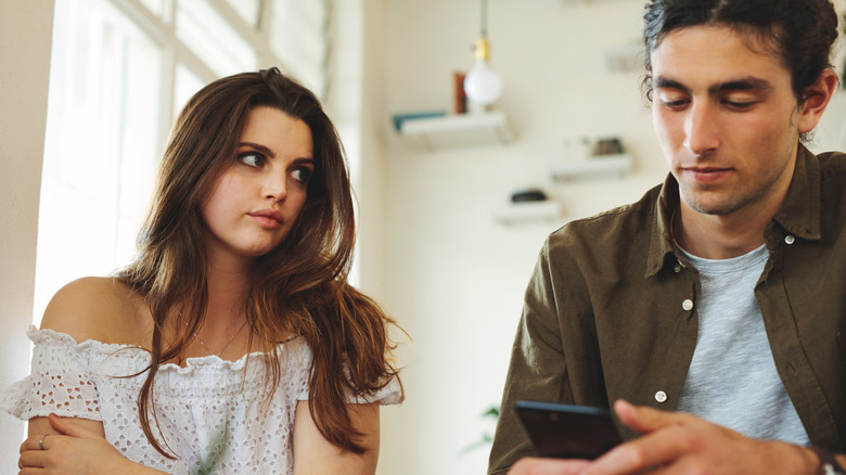 Woman irritated, guy looking at phone