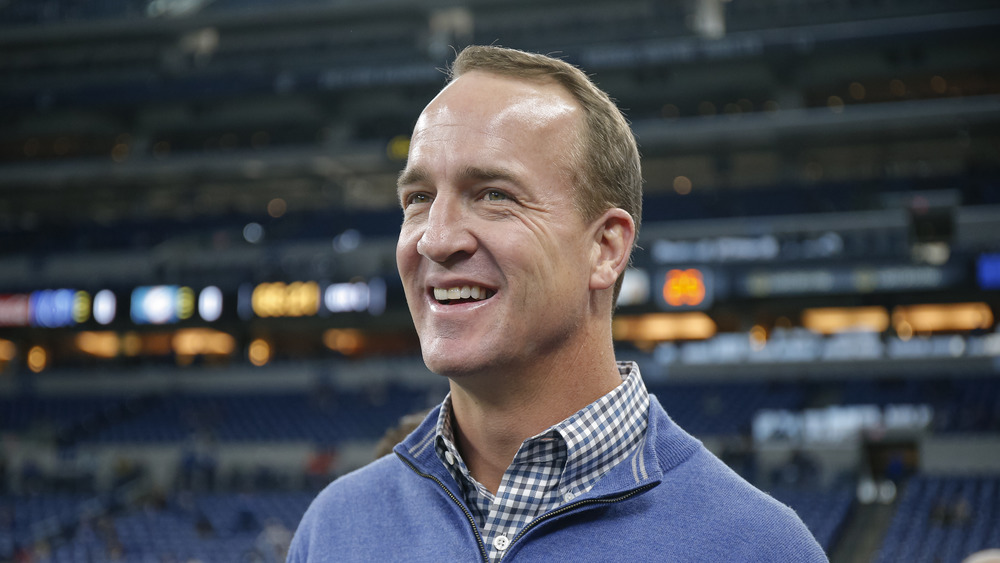 Peyton Manning smiling on field in street clothes