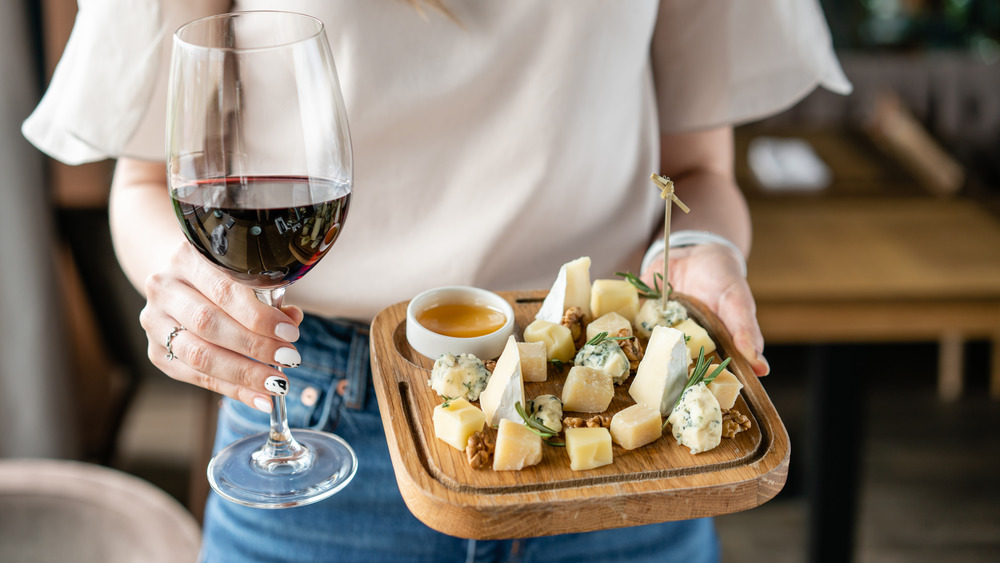 Woman holding cheese and wine