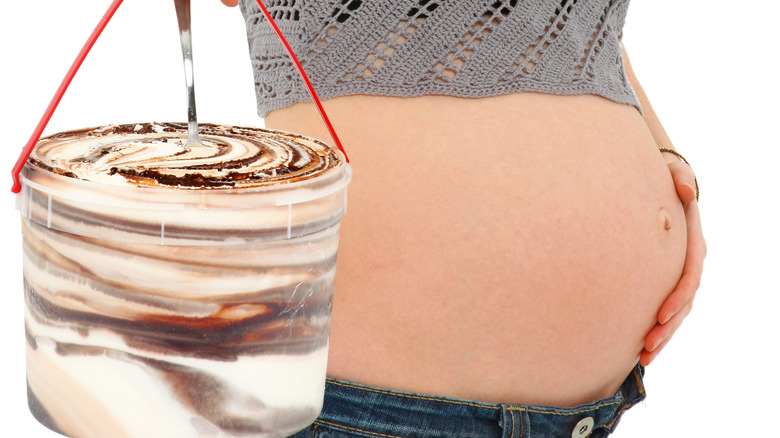 Pregnant woman holding bucket of ice cream