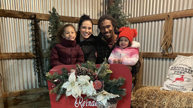 Trae Waynes and Kyra Luther posing with kids