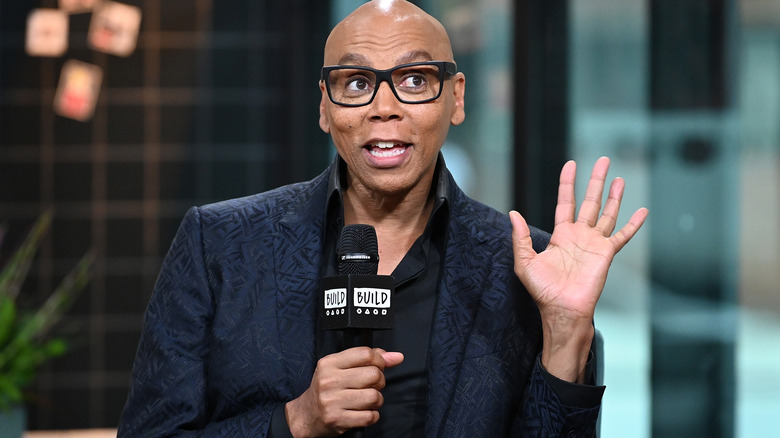 RuPaul Charles holds up his hand during an interview