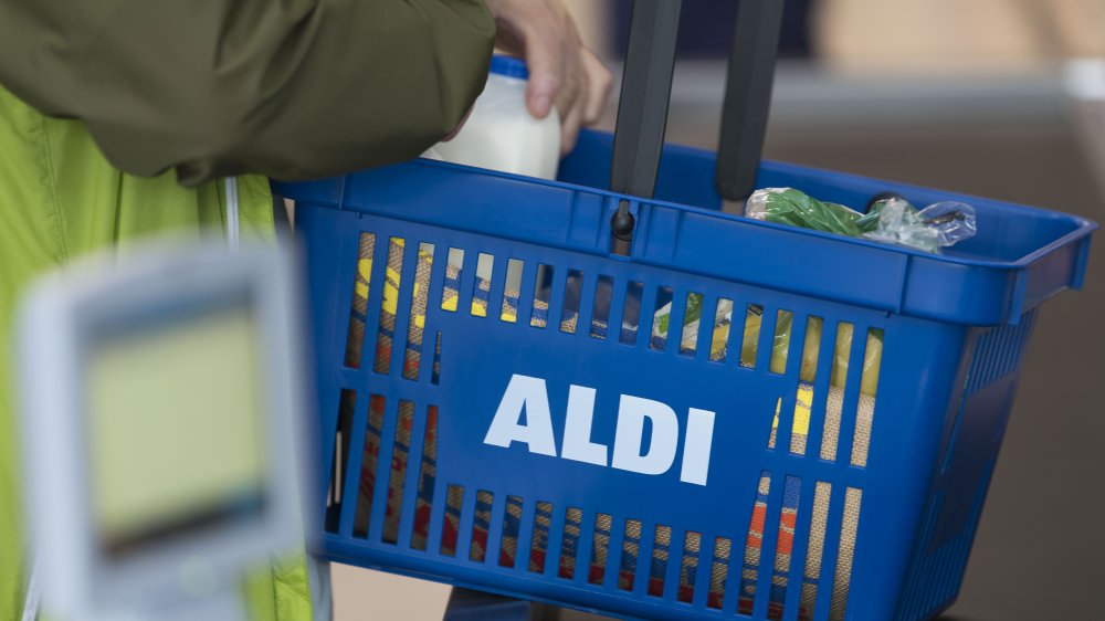 Shopper unloading basket in Aldi checkout line