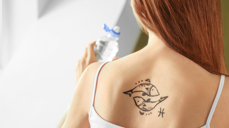 Woman with Pisces zodiac tattoo